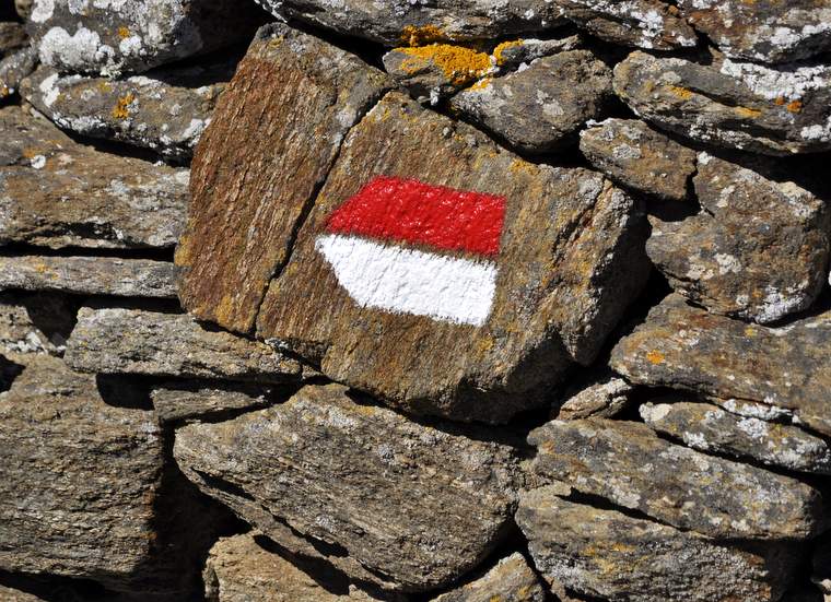 A white and red arrow waymark on the tails of Sifnos, Greece