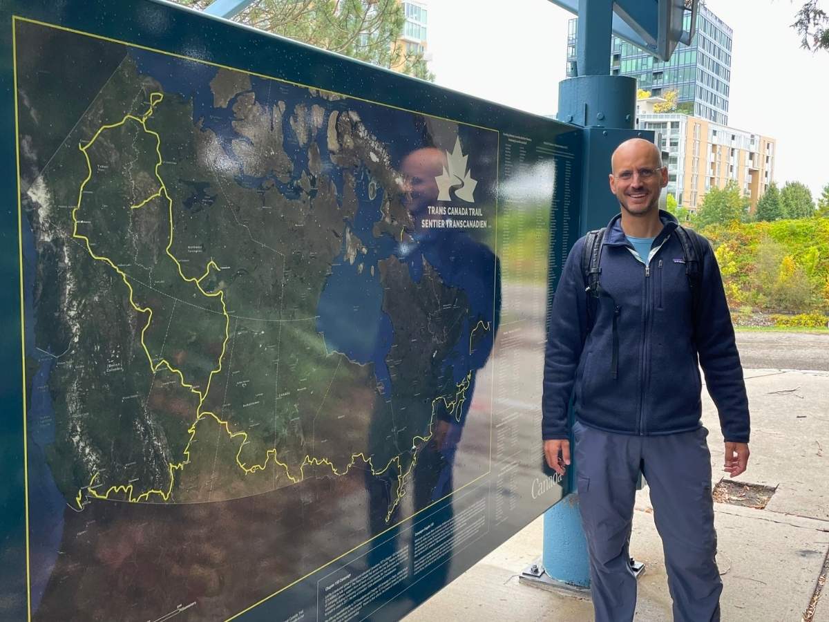 Fivos Tsaravopoulos in front of a Trans Canada Trail Map in Ottawa