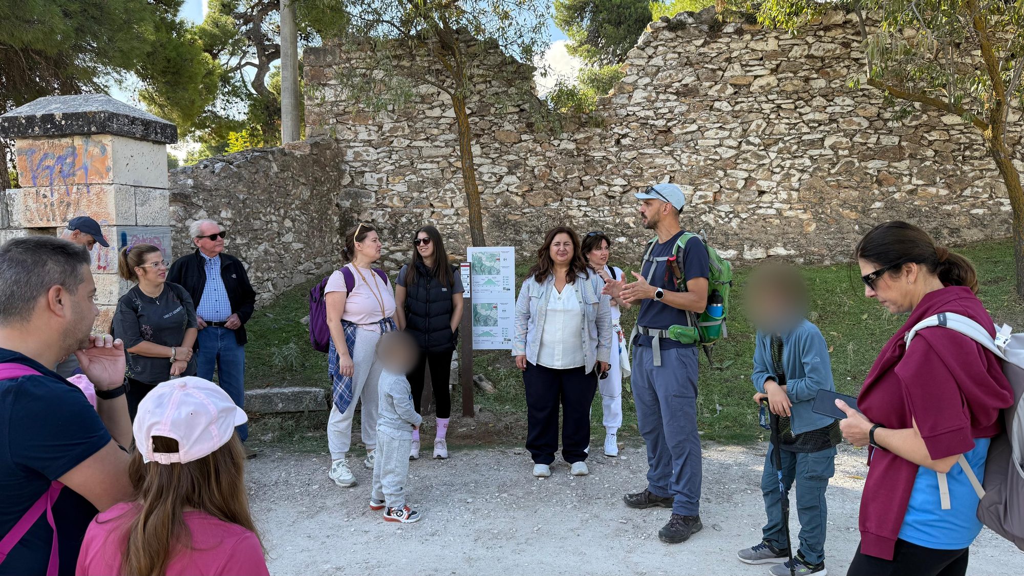 Paths of Greece guide briefing hikers in front of the D1 trail sign on Mount Penteli
